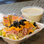 chef salad in Styrofoam container with plastic container of ranch