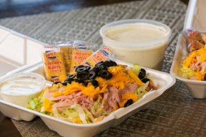 chef salad in Styrofoam container with plastic container of ranch